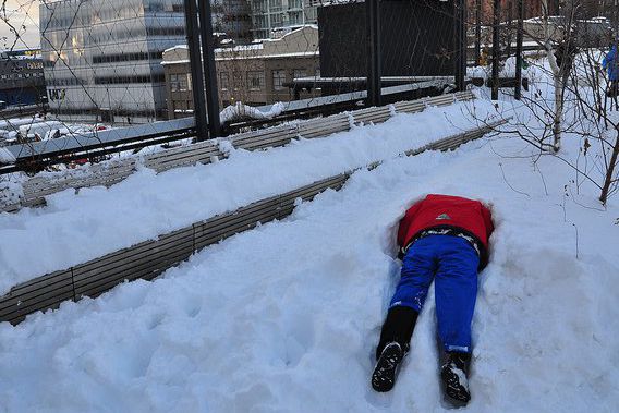 This is a photo of a child lying face down in a snow bank.